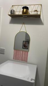 a mirror on a wall next to a shelf at BVapartments-Blackhouse F2 in Huddersfield