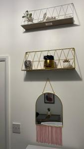 a mirror hanging on a wall with a shelf at BVapartments-Blackhouse F2 in Huddersfield