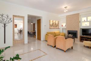 sala de estar con sofá amarillo y TV en Chrissiida Villa, en Ialisos