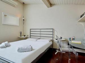 ein Schlafzimmer mit einem weißen Bett und einem Stuhl in der Unterkunft Settembrini in Mailand