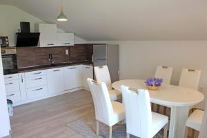 a kitchen with a white table and white chairs at Apartman Lavanda in Krapina