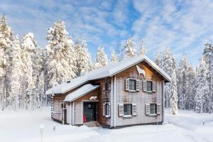 a wooden cabin in the snow with snow covered trees at Ranua Resort Holiday Villas in Ranua