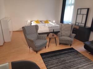Un dormitorio con una cama y dos sillas y una mesa. en Apartmán Nad Kolonádou, en Karlovy Vary