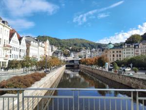 Una vista de un río en una ciudad con edificios. en Apartmán Nad Kolonádou, en Karlovy Vary