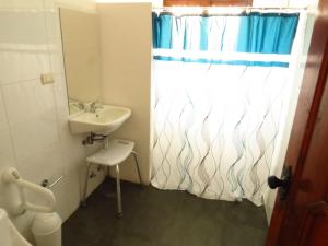 a bathroom with a sink and a shower curtain at Costanera240 in El Quisco