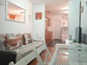 een woonkamer met een bank en een glazen tafel bij Apartamento Con Encanto 'Larios Studio' in Málaga