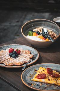 a table with plates of food and bowls of fruit at Villa Sonnenhof Boutique-Hotel in Bad Reichenhall
