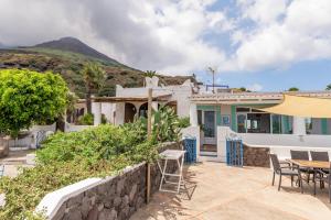 una casa con patio arredato con tavolo e sedie di Villa Mareblu Luxury Holiday Apartment direttamente sul mare a Stromboli