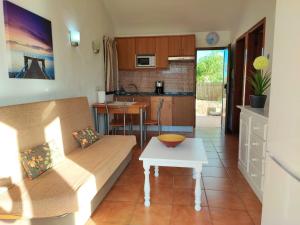 ein Wohnzimmer mit einem Sofa und einem Tisch in der Unterkunft Bungalow Santa Fe en centro de Playa del Inglés in Maspalomas