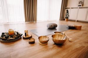 ein Zimmer mit Schalen und anderen Gegenständen auf dem Boden in der Unterkunft Okelmann's - Entspannte Achtsamkeit - Bewusster Lifestyle in Warpe