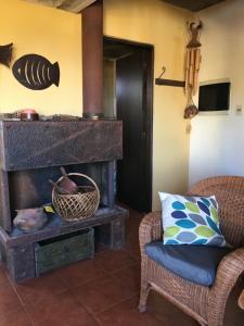 a living room with a fireplace and a chair at Casa Bacana in Punta Del Diablo