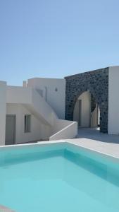 vista sulla piscina di fronte a un edificio di Noir Santorini a Monolithos