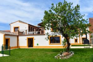 a house with a tree in the yard at Casa Rural de Ancos, Guadamur, Toledo in Guadamur