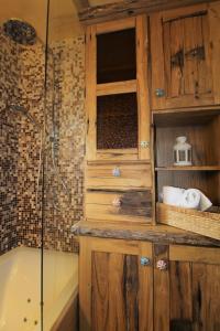 a bathroom with a wooden cabinet and a bath tub at TEDDYBÄR ski-to-door Studio in Bad Kleinkirchheim