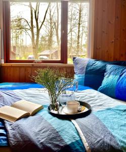 a tray on a bed with a plate with a coffee cup at Ferienhäuser Pannier I und oder II in Gartow