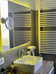 a bathroom with a white sink and a mirror at Zeta Rooms in Caserta
