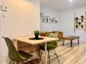 a dining room with a table and green chairs at Le bohémien - Condos Saint-Côme in Saint Come