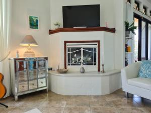 a living room with a fireplace and a tv at Villa Corazón - private beach at Lake Arenal in Nuevo Arenal