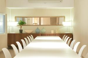 una sala da pranzo con un lungo tavolo e sedie bianche di Hotel Omnium a Barcellona