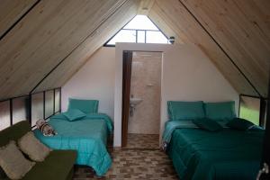 a attic room with two beds and a window at Hospedaje Villa Rosita Suesca in Suesca