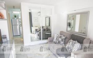 ein Wohnzimmer mit einer Couch und einem Spiegel in der Unterkunft 1016 Piscis Apartamentos - VISTAS AL MAR - Piscina y Playa in Benalmádena