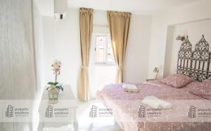 ein Schlafzimmer mit einem Bett mit einer lila Tagesdecke in der Unterkunft 1016 Piscis Apartamentos - VISTAS AL MAR - Piscina y Playa in Benalmádena + 36 Fotos