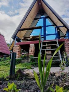 uma pequena casa com telhado de palha e escadas em Hospedaje Villa Rosita Suesca em Suesca