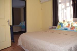 a bedroom with a bed and a large window at Oasis Kite Appartment in La Gaulette