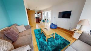 a living room with a couch and a table at Cosy Town House Sleeps 8 in Pembroke Dock
