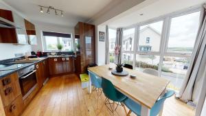 a kitchen with a wooden table and blue chairs at Cosy Town House Sleeps 8 in Pembroke Dock