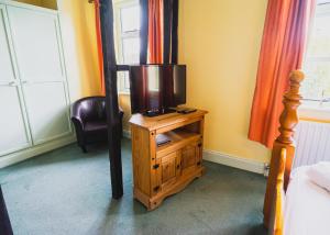 a tv on a wooden stand in a bedroom at The Mug House Inn in Bewdley