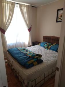 um quarto com uma cama grande e uma janela em Departamento, Playa Bellavista, Tomé em Tomé