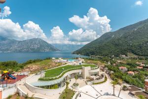 arial view of a resort with a lake and mountains at Lavender Bay Lux Apartment G5 in Donji Morinj