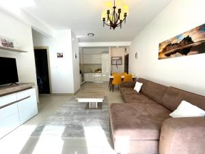a living room with a couch and a tv at Lavender Bay Lux Apartment G5 in Donji Morinj
