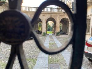 een uitzicht op een binnenplaats via een hek met een ketting bij Palazzo Della Torre Room in Verona