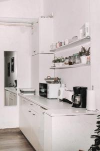 uma cozinha com armários brancos e uma bancada em Alandala by The Center em Cluj-Napoca