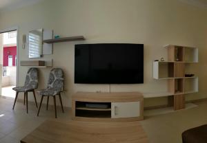 - un salon avec une télévision à écran plat et deux chaises dans l'établissement Maravillosa by "BahiaMarCanarias", à La Estrella