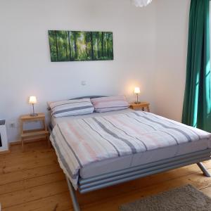 a bedroom with a bed with two lamps on two tables at Landhof Ella - Ferienhaus vor den Toren Salzburgs in Petting