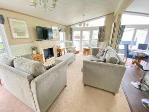 a large living room with couches and a fireplace at Wildflower, Premium Plus Hot Tub Lodge in South Cerney