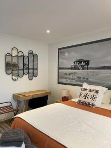 - une chambre avec un lit et une photo de la plage dans l'établissement VILLA MADY, à Andernos-les-Bains