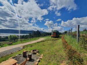 un tren viajando por un camino al lado de una valla en GLAMCAPTOUR, en Guatavita