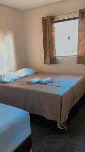 1 dormitorio con 1 cama grande y ventana en Chalés Vila Bela Vale do Capão en Vale do Capao