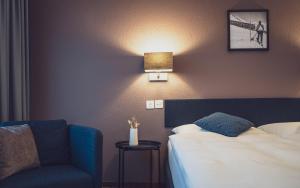 达沃斯Hotel Ochsen by Mountain Hotels的一间带床和椅子的酒店房间