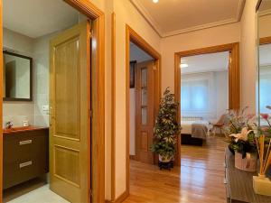 pasillo con puerta y habitación con dormitorio en Apartamento Baztán, en Elizondo