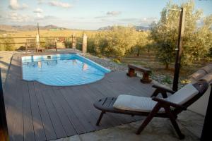 a deck with a chair and a swimming pool at Victoria & Olivar in Málaga