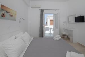 a white bedroom with a bed and a sink at Evas House in Fira