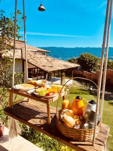 een tafel met een mand met eten op een schommel bij Pura Vida Guest House in Ilhabela