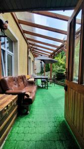 a patio with a couch and a table and an umbrella at Brama Bieszczad in Lesko