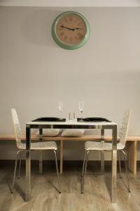 een eettafel met stoelen en een klok aan de muur bij Idyllic Apartment with Terrace in Barcelona