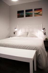 バルセロナにあるIdyllic Apartment with Terraceの白いベッド1台、壁に絵画2点が備わるベッドルーム1室